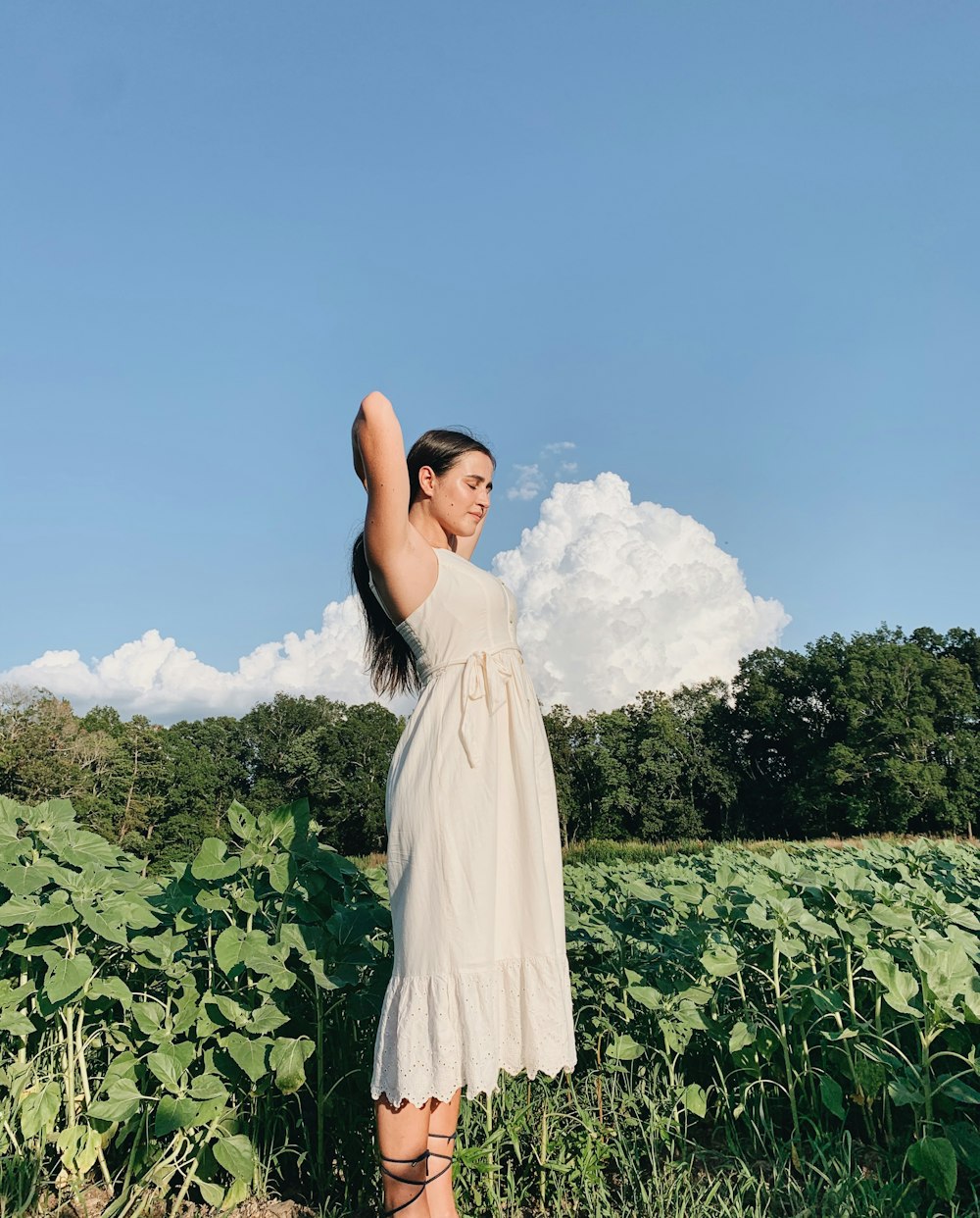 woman in white dress standing on green grass field during daytime