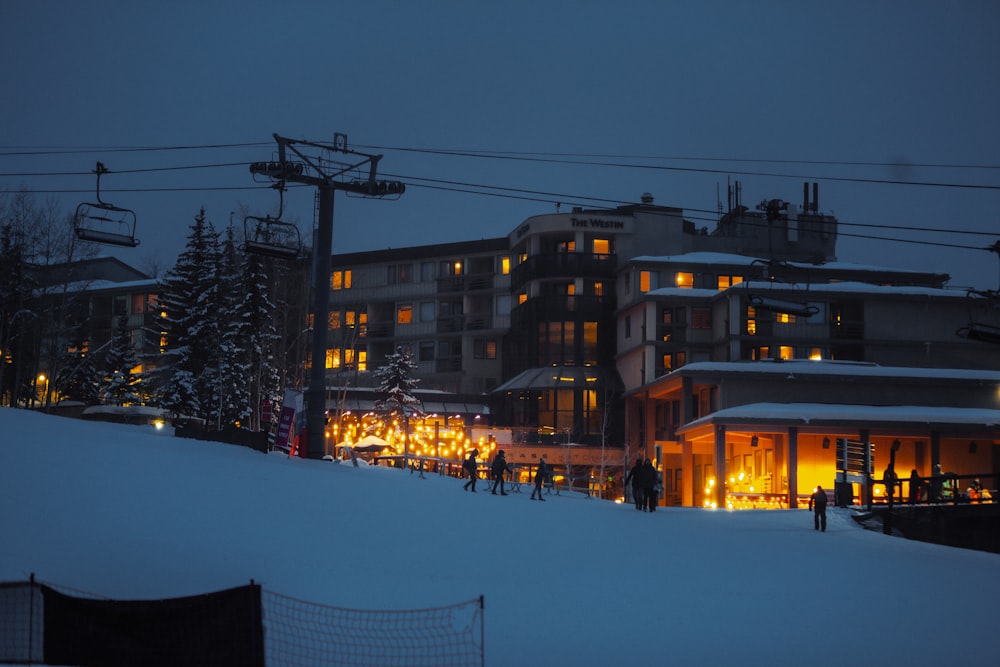 people walking on snow covered ground near building during night time