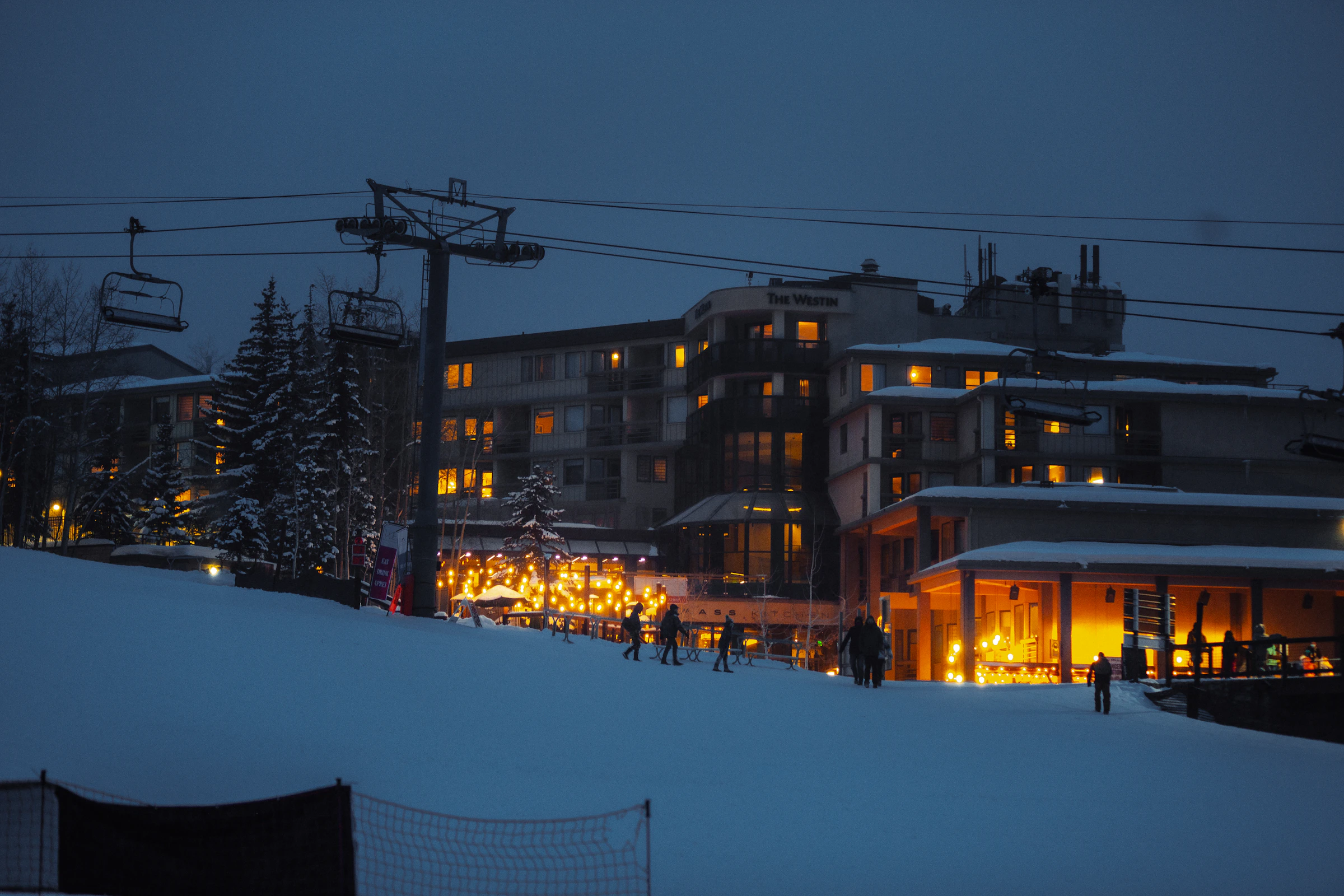 Snowmass Village at dusk with snow-covered slopes and a chairlift