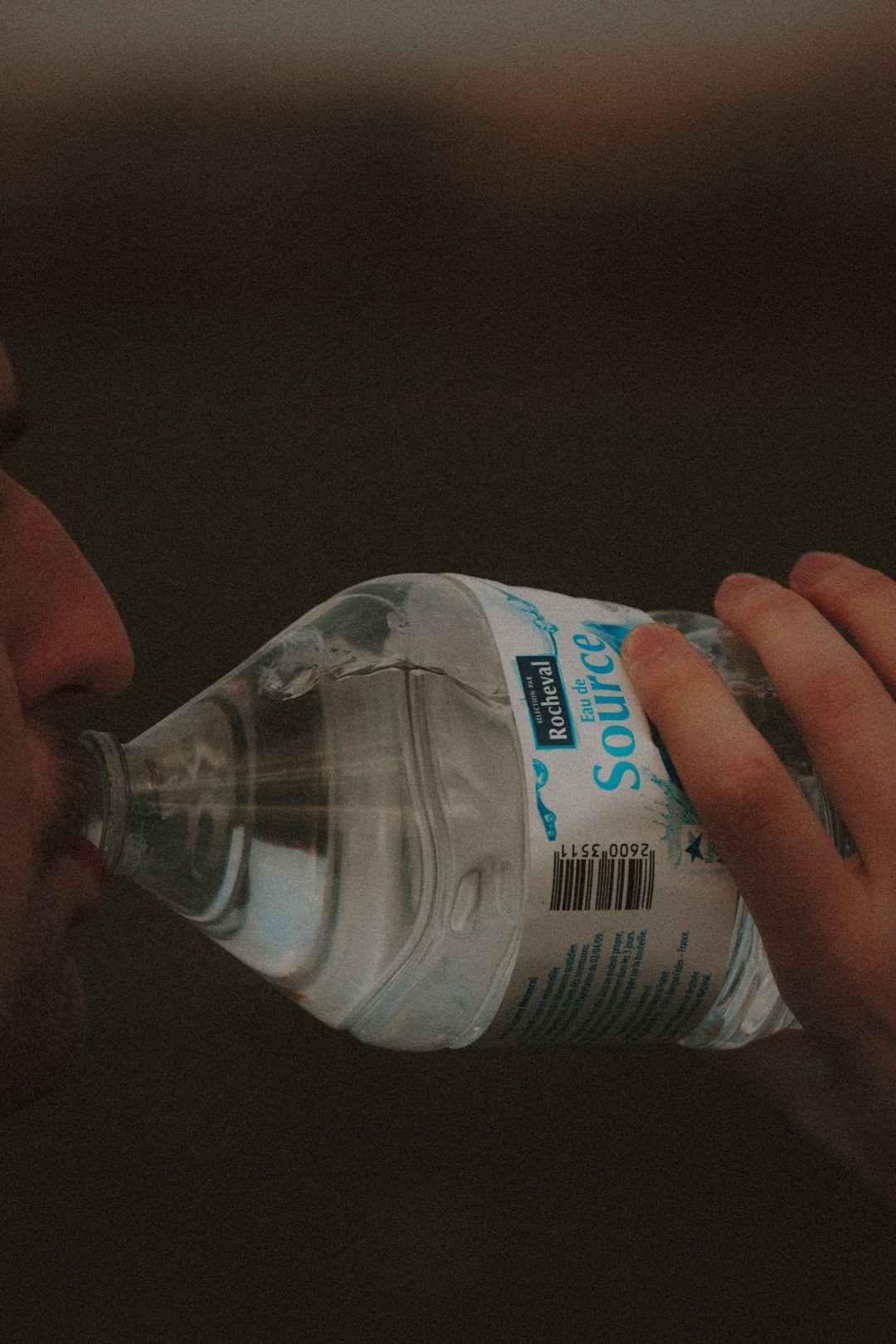 person holding white and blue labeled bottled water