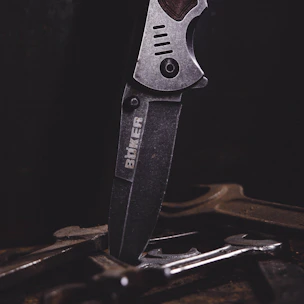 Close-up of a stainless steel professional ham holder with laser engraving details on a wooden table.