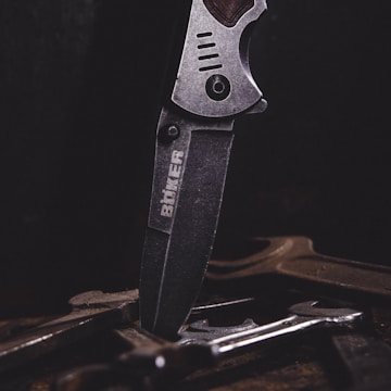 Close-up of a stainless steel branding iron with laser-cut precision resting on a wooden surface.