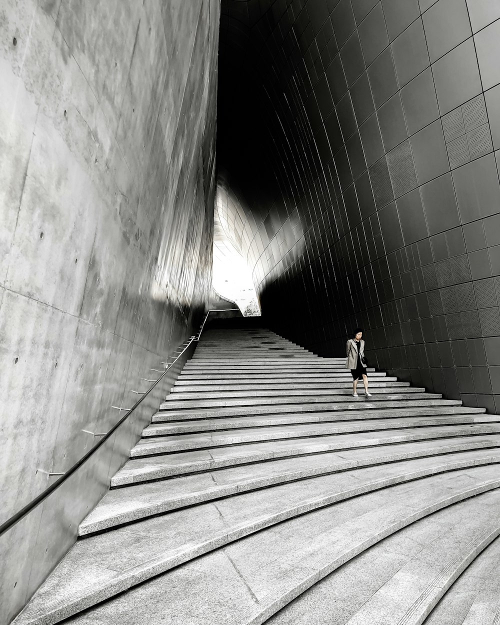 woman in black shirt walking on gray concrete tunnel