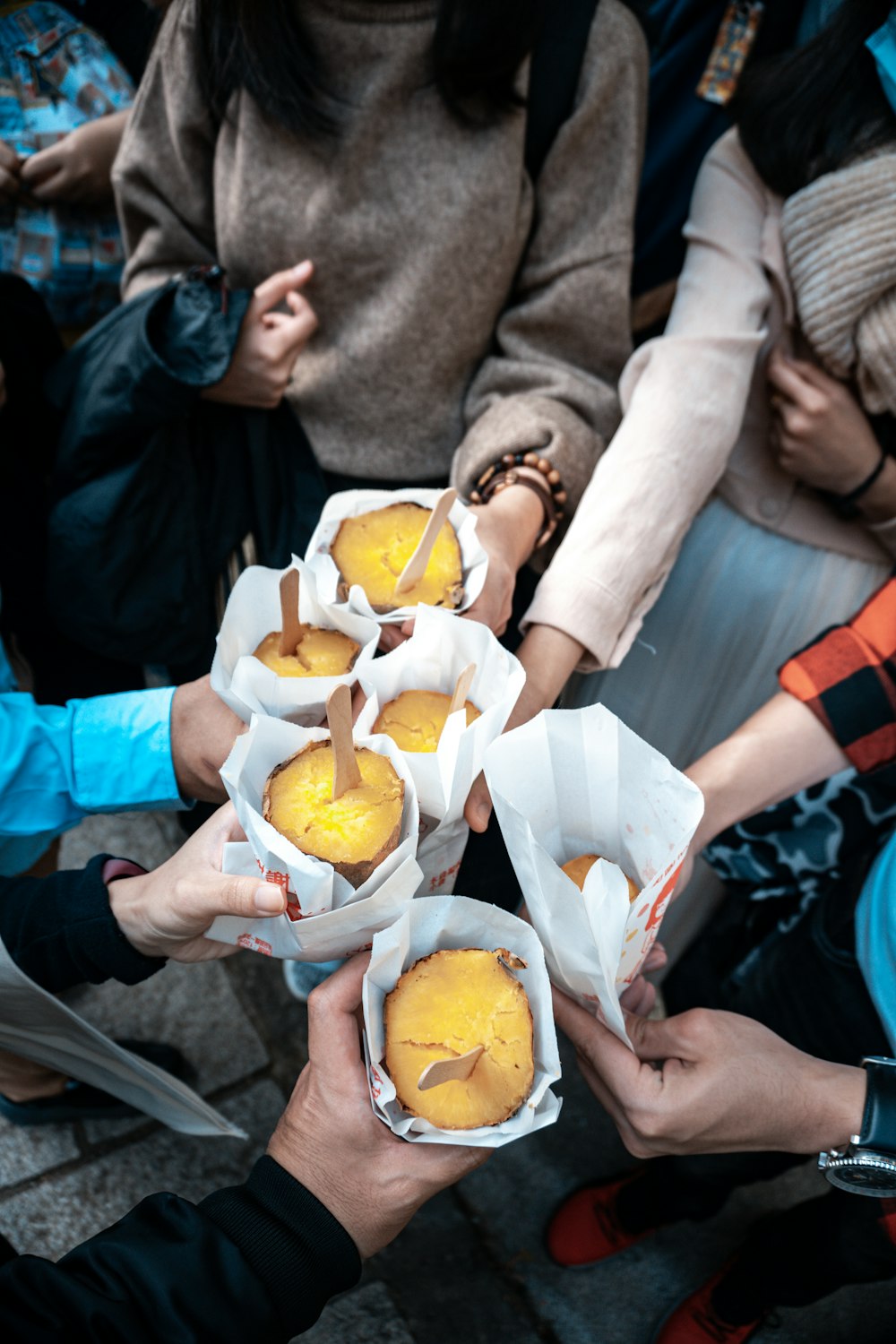 person in brown jacket holding orange fruit