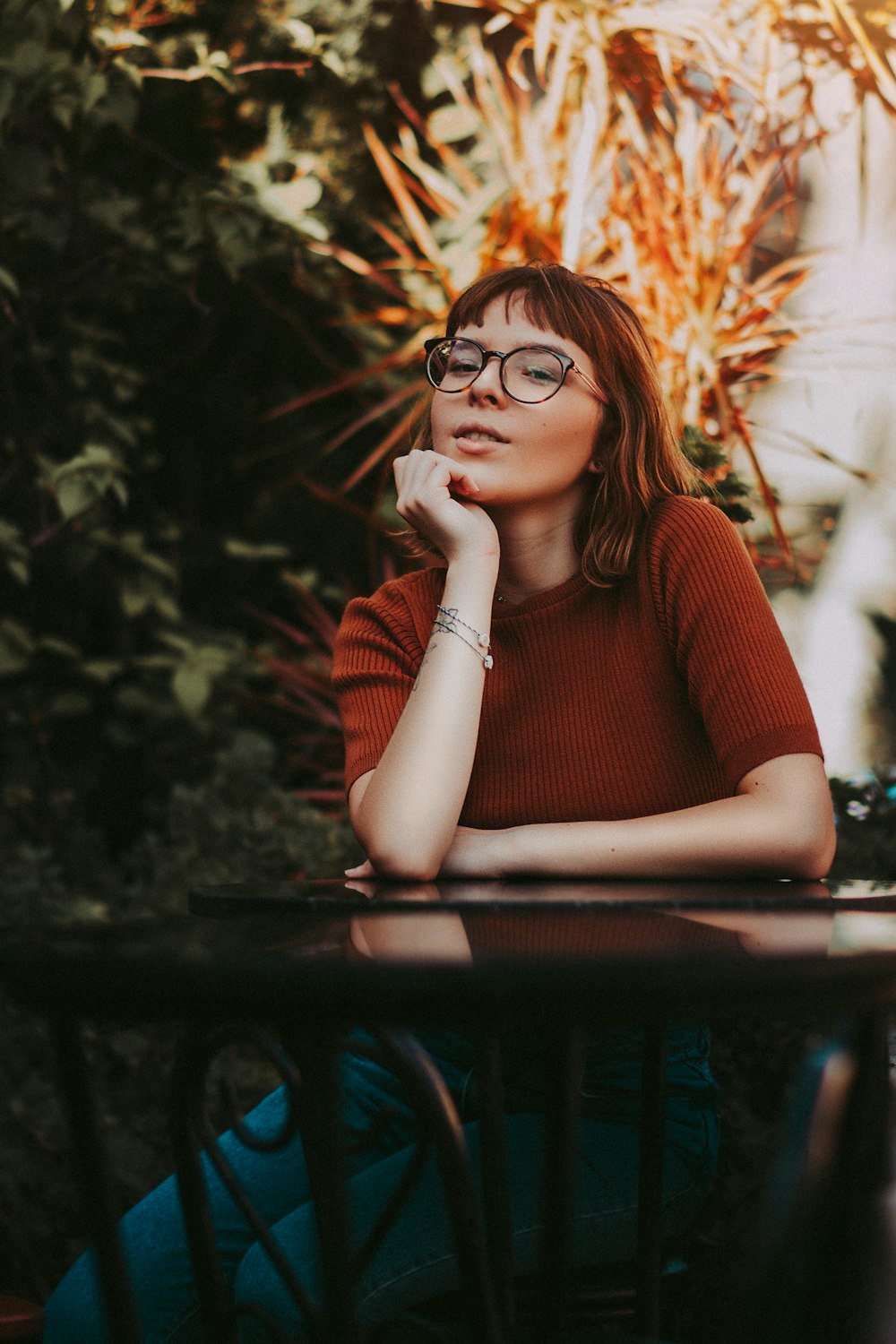 woman in red long sleeve shirt wearing black framed eyeglasses