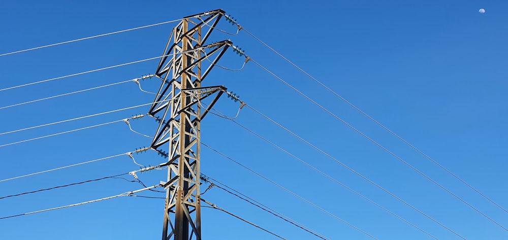 black electric post under blue sky during daytime