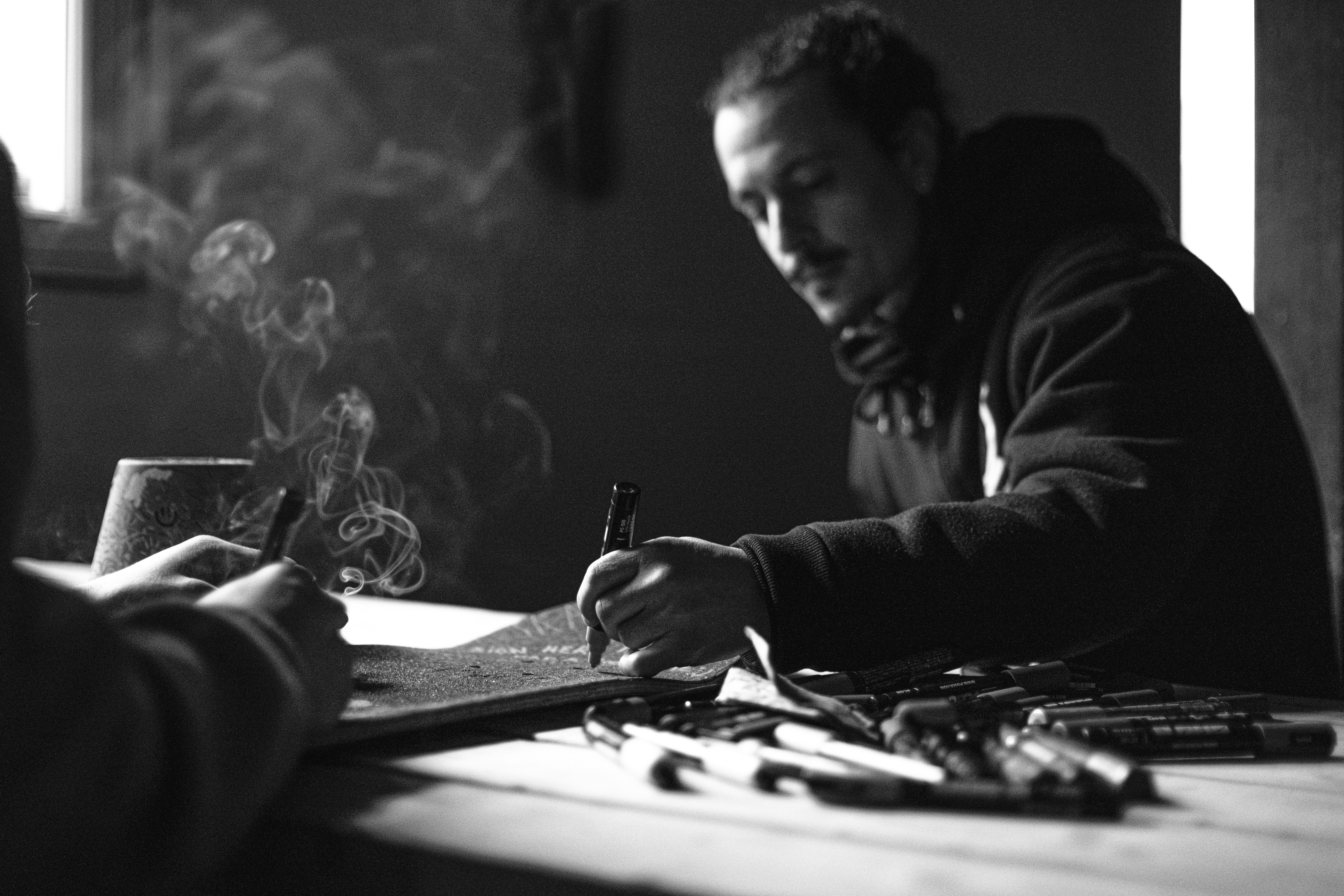 man in black jacket holding pen