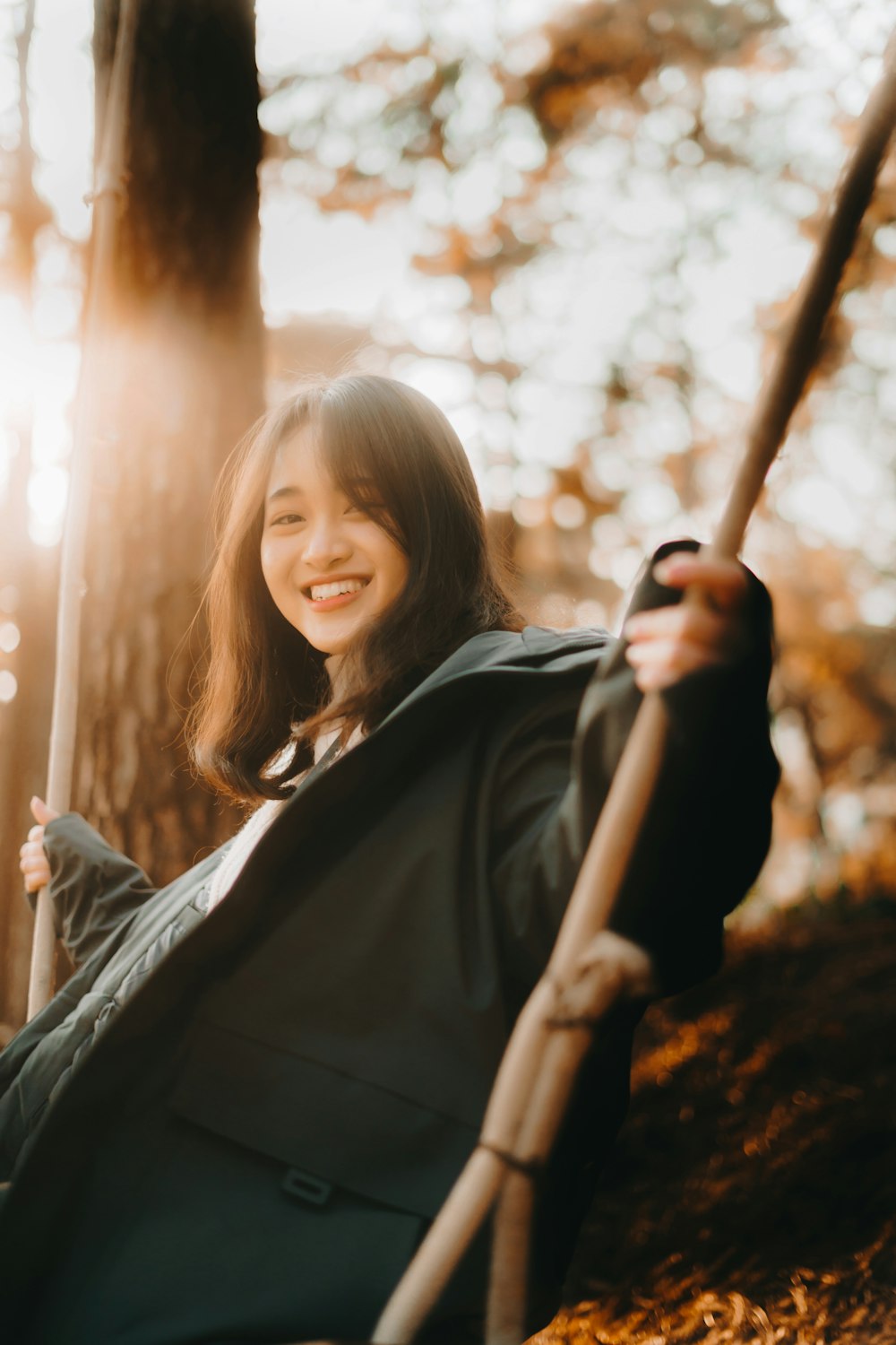 woman in black long sleeve shirt holding brown stick during daytime