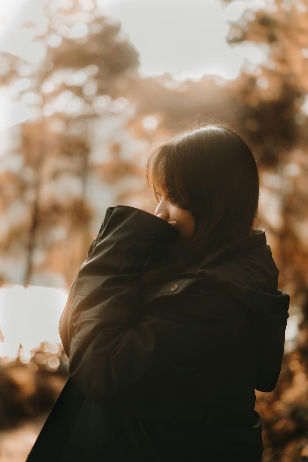 woman in black jacket looking at the sun