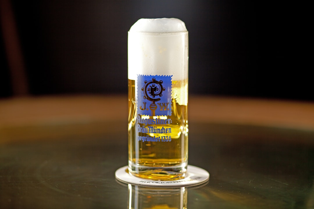 white and gold can on black table, glass of beer on a table