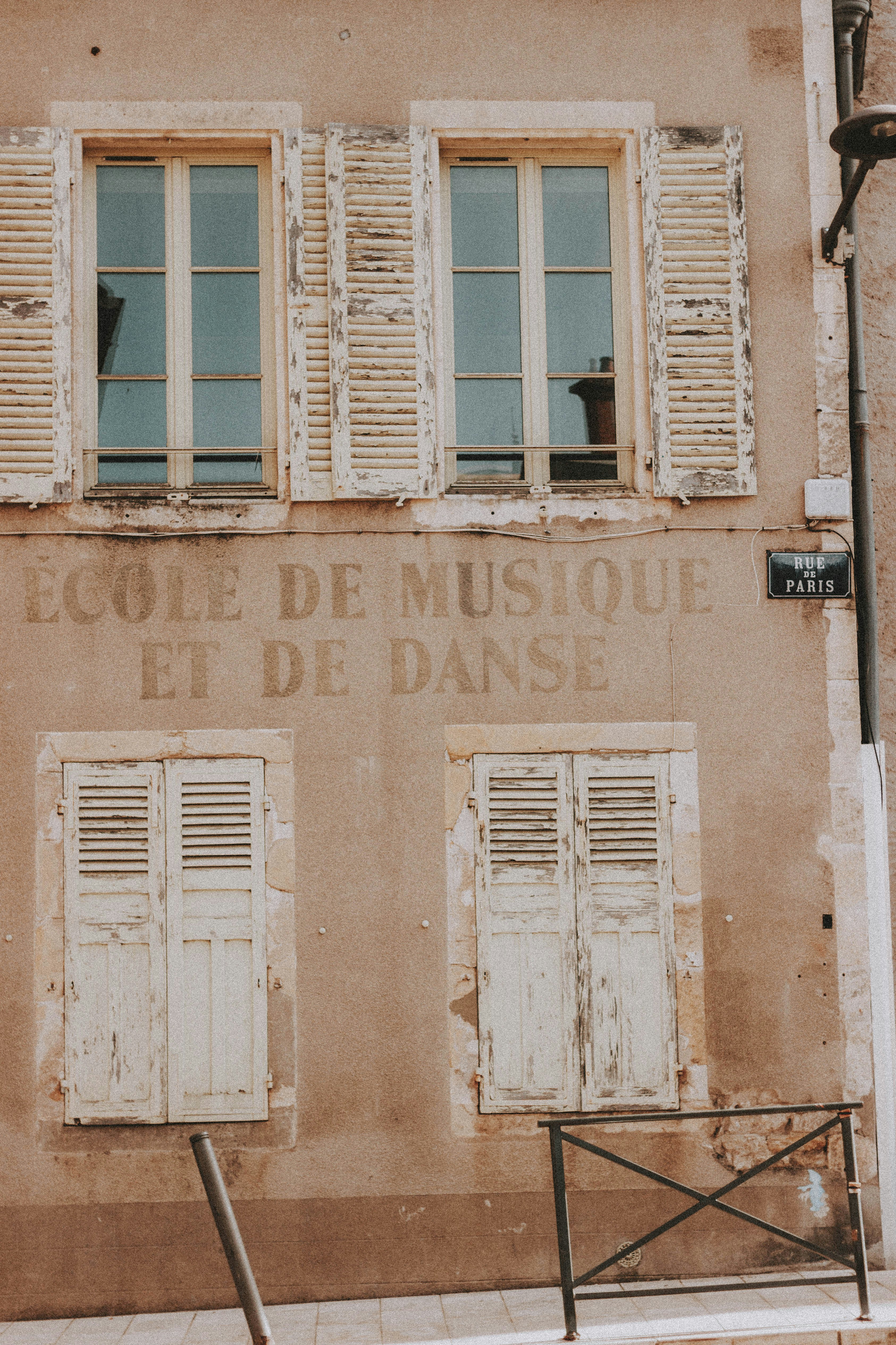Bâtiment en béton brun avec fenêtre en bois blanc