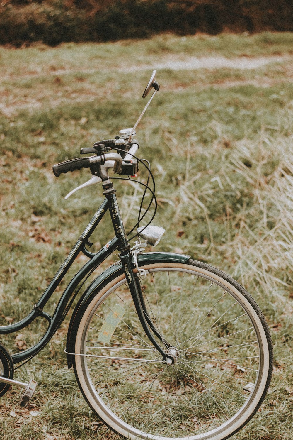 bicicleta preta no campo de grama marrom durante o dia