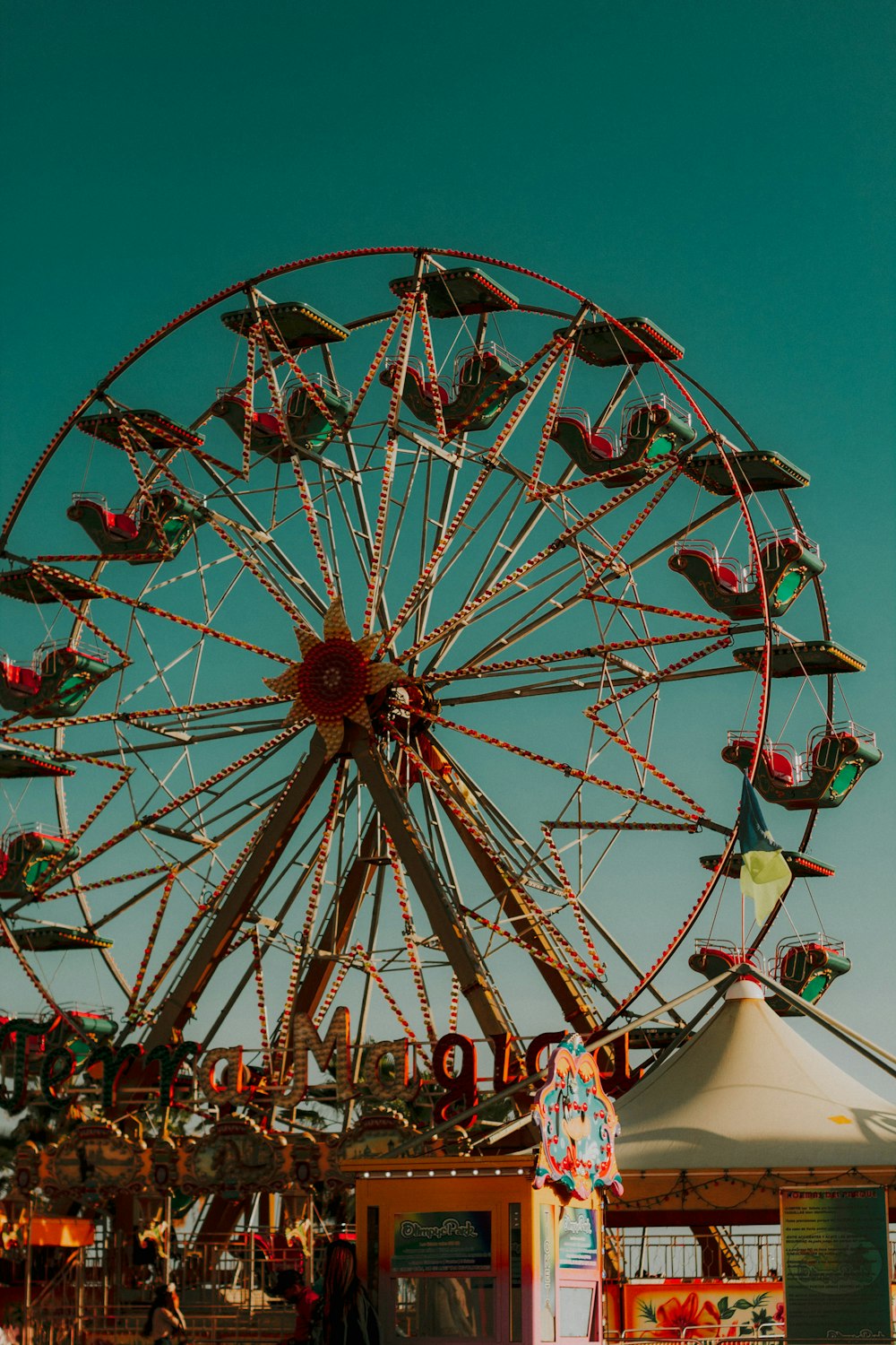 red and white ferris wheel under blue sky during daytime