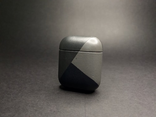 Earpods cases in neutral tones with subtle pink accents, displayed on a clean, modern desk setup.