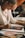 woman in white long sleeve shirt writing on white paper