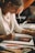 woman in white long sleeve shirt writing on white paper