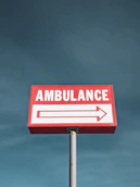 a red and white sign that says ambulance