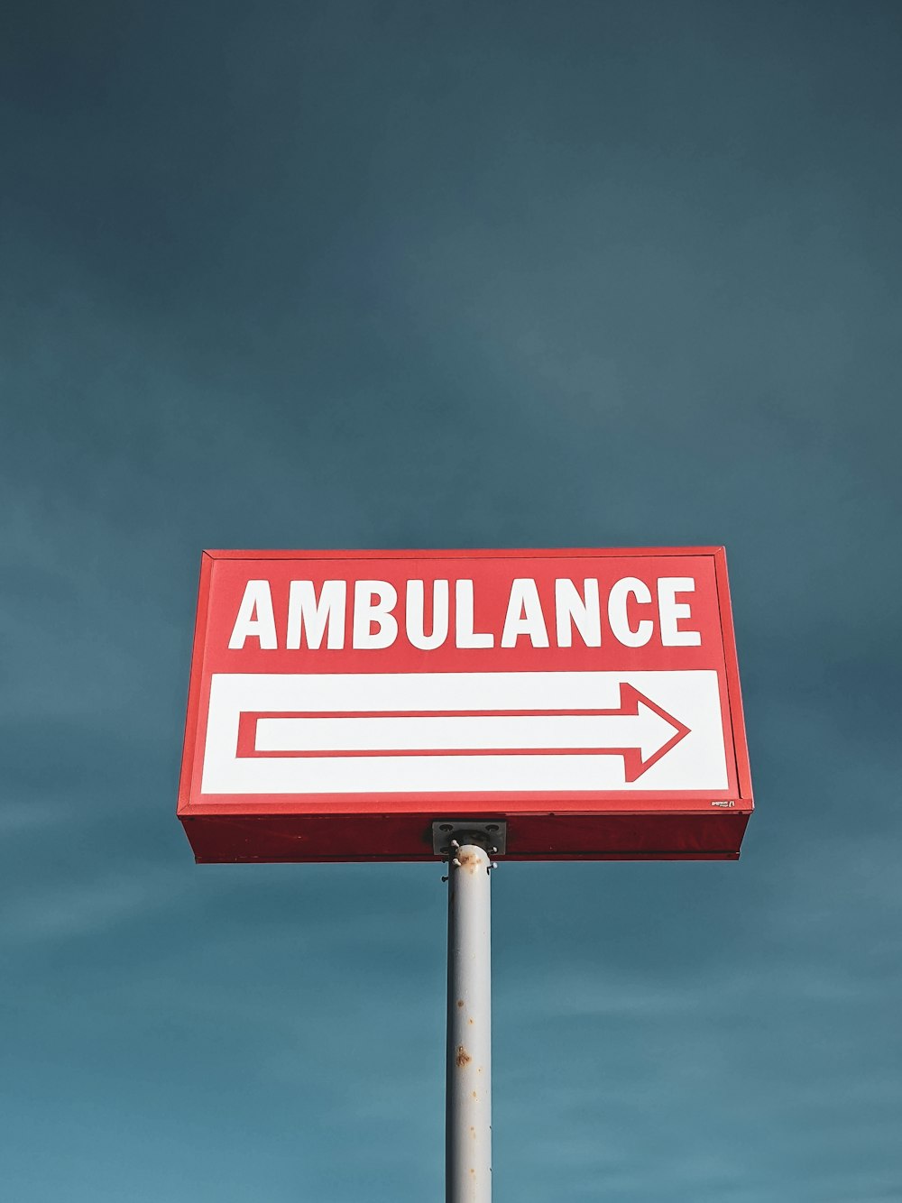 a red and white sign that says ambulance