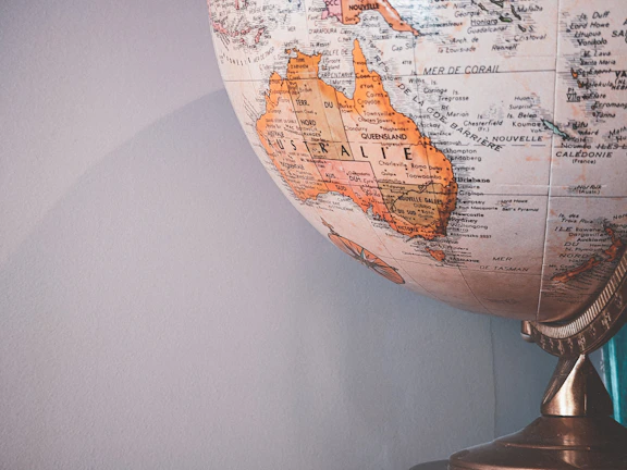 A wall-mounted world map highlighting key trade routes between Australia and Asia with subtle blue accents.