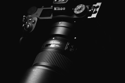 black nikon dslr camera on black surface