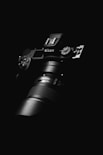 black nikon dslr camera on black surface