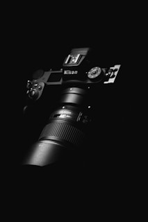 black nikon dslr camera on black surface