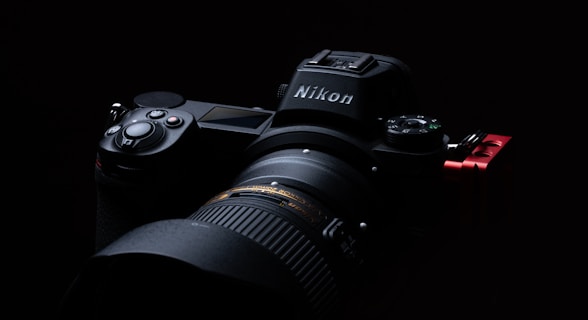 black nikon dslr camera on black surface