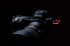 black nikon dslr camera on black surface