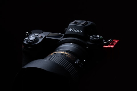 black nikon dslr camera on black surface