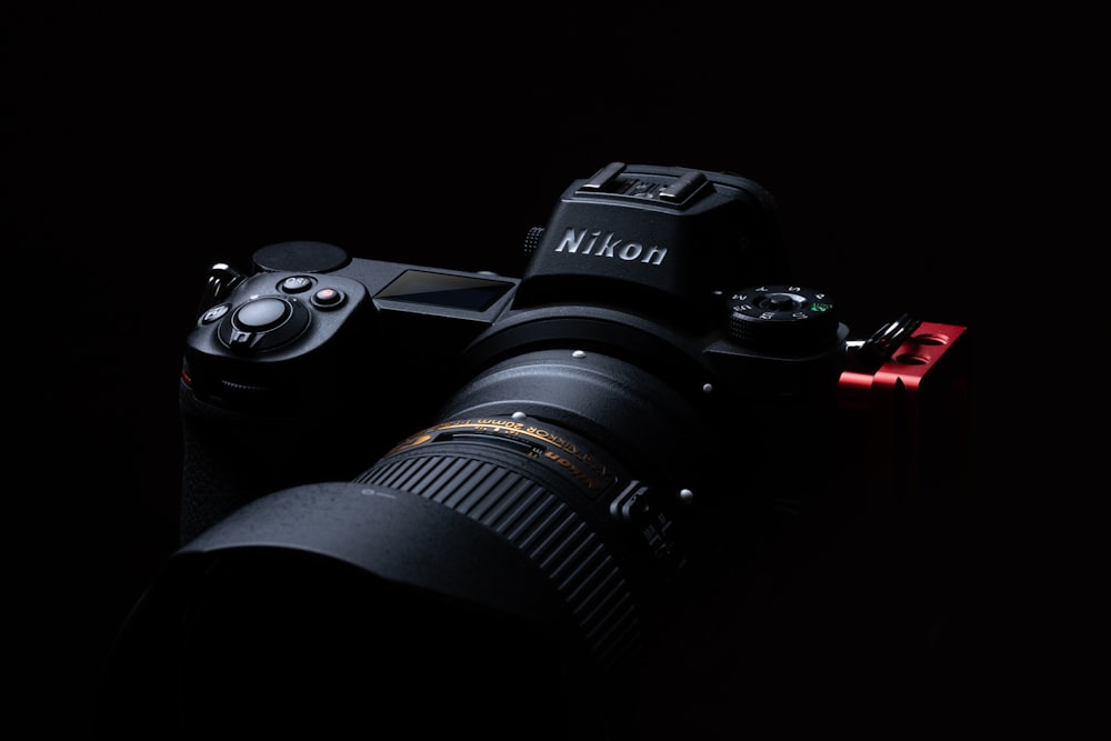 Appareil photo reflex numérique Nikon noir sur surface noire