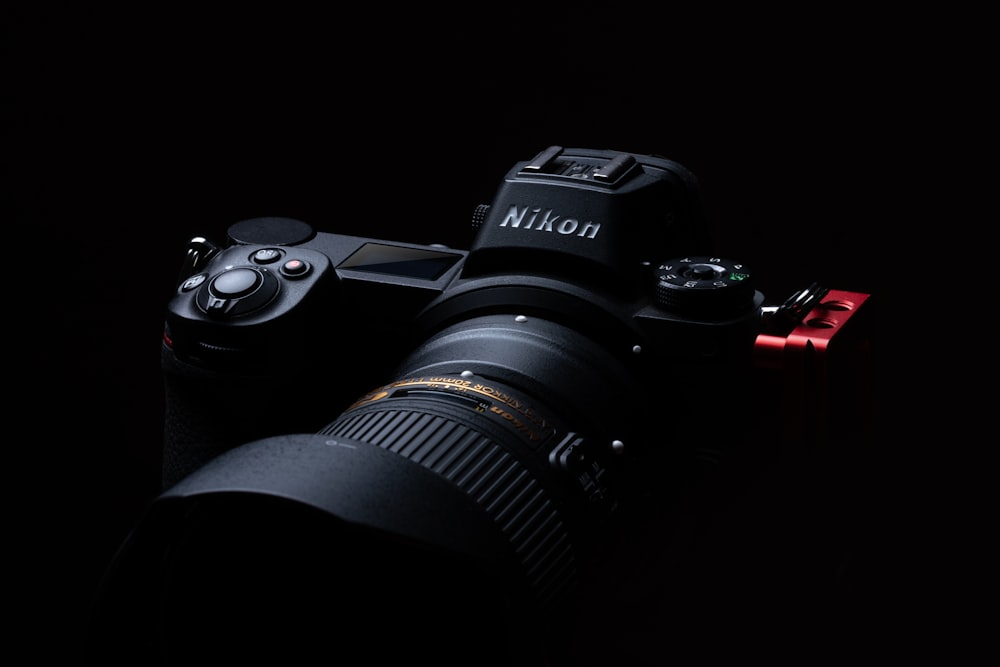 Schwarze Nikon DSLR-Kamera auf schwarzer Oberfläche