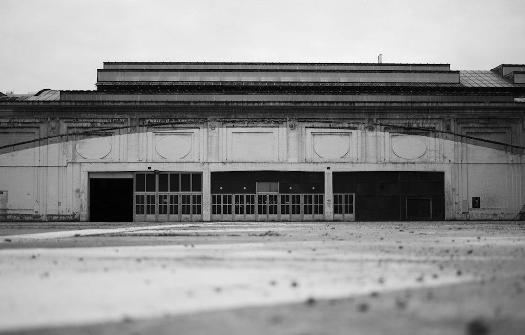 grayscale photo of building under cloudy sky