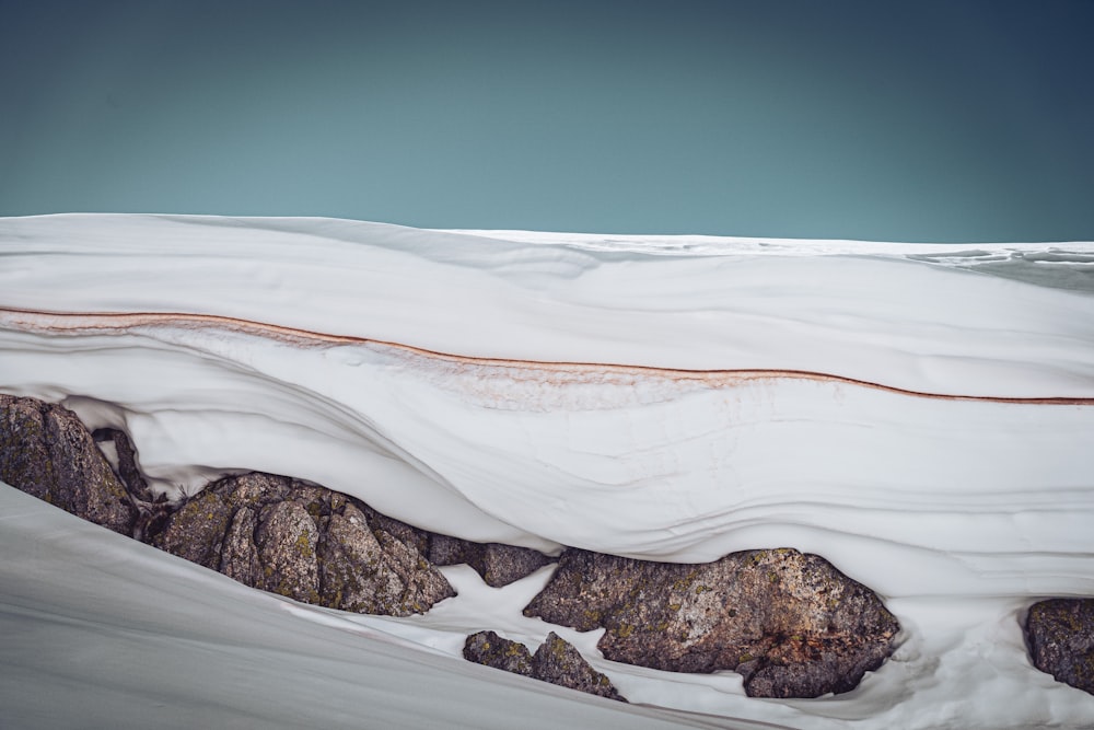 Formation rocheuse brune sur un champ de neige blanche pendant la journée