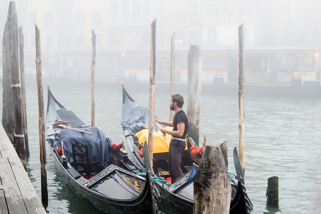 man in black and white boat on body of water during daytime