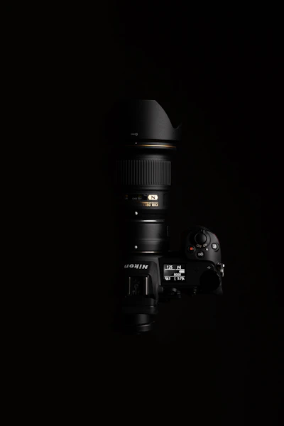 black nikon dslr camera on black surface