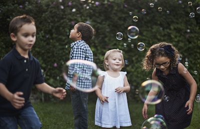 A group of joyful children playing together in a sunny community garden.