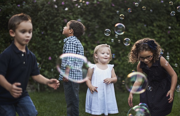 Kids playing together in a green outdoor garden during a fun group activity