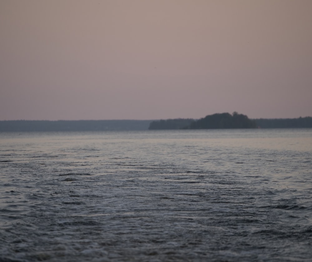 body of water near mountain during daytime