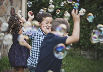 boy in blue and white polka dot shirt playing bubbles