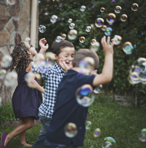 boy in blue and white polka dot shirt playing bubbles