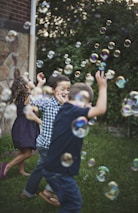 boy in blue and white polka dot shirt playing bubbles