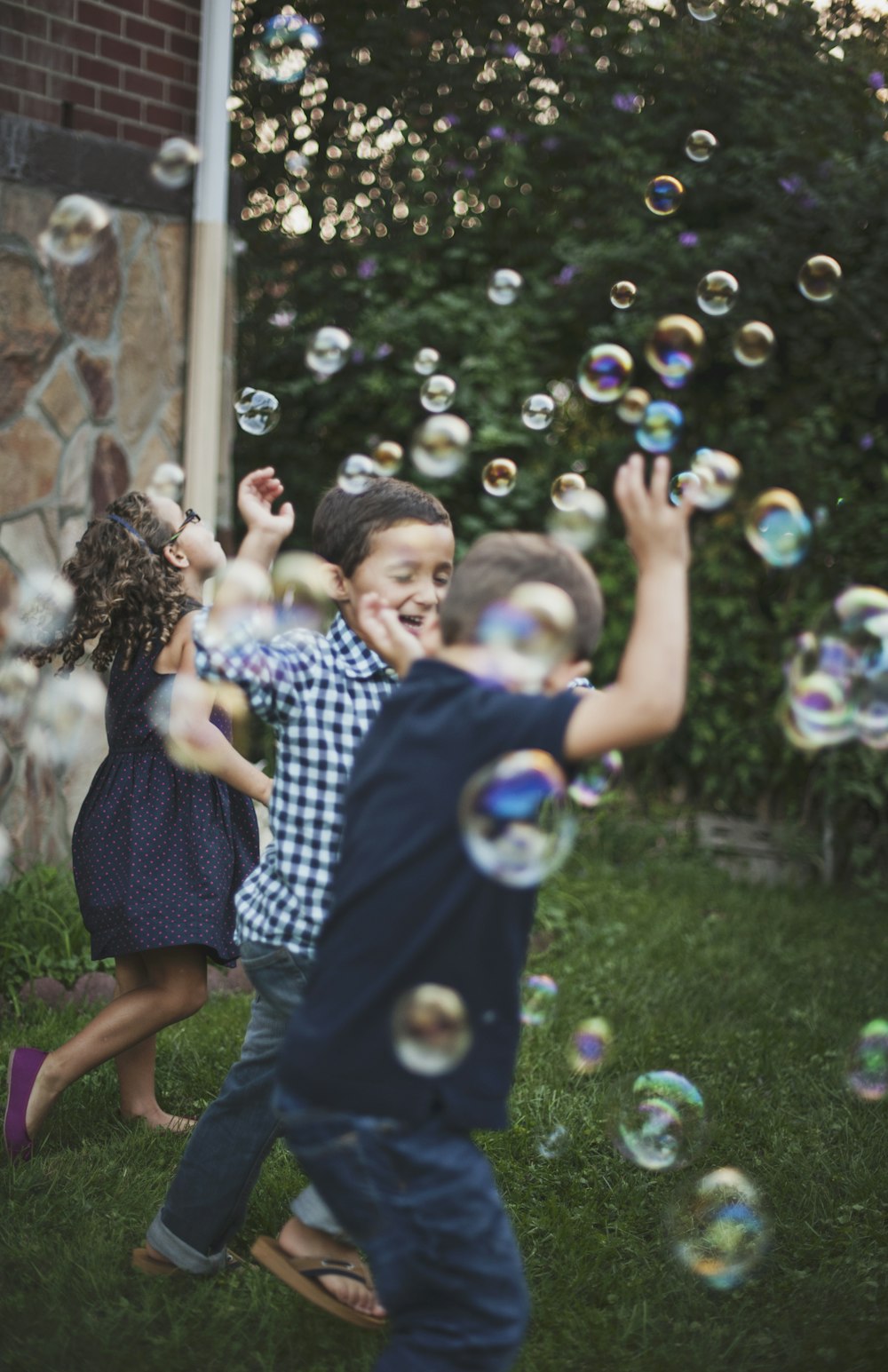 Chico con camisa de lunares azul y blanco jugando a las burbujas