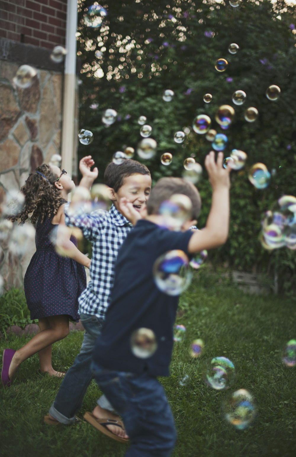 boy in blue and white polka dot shirt playing bubbles