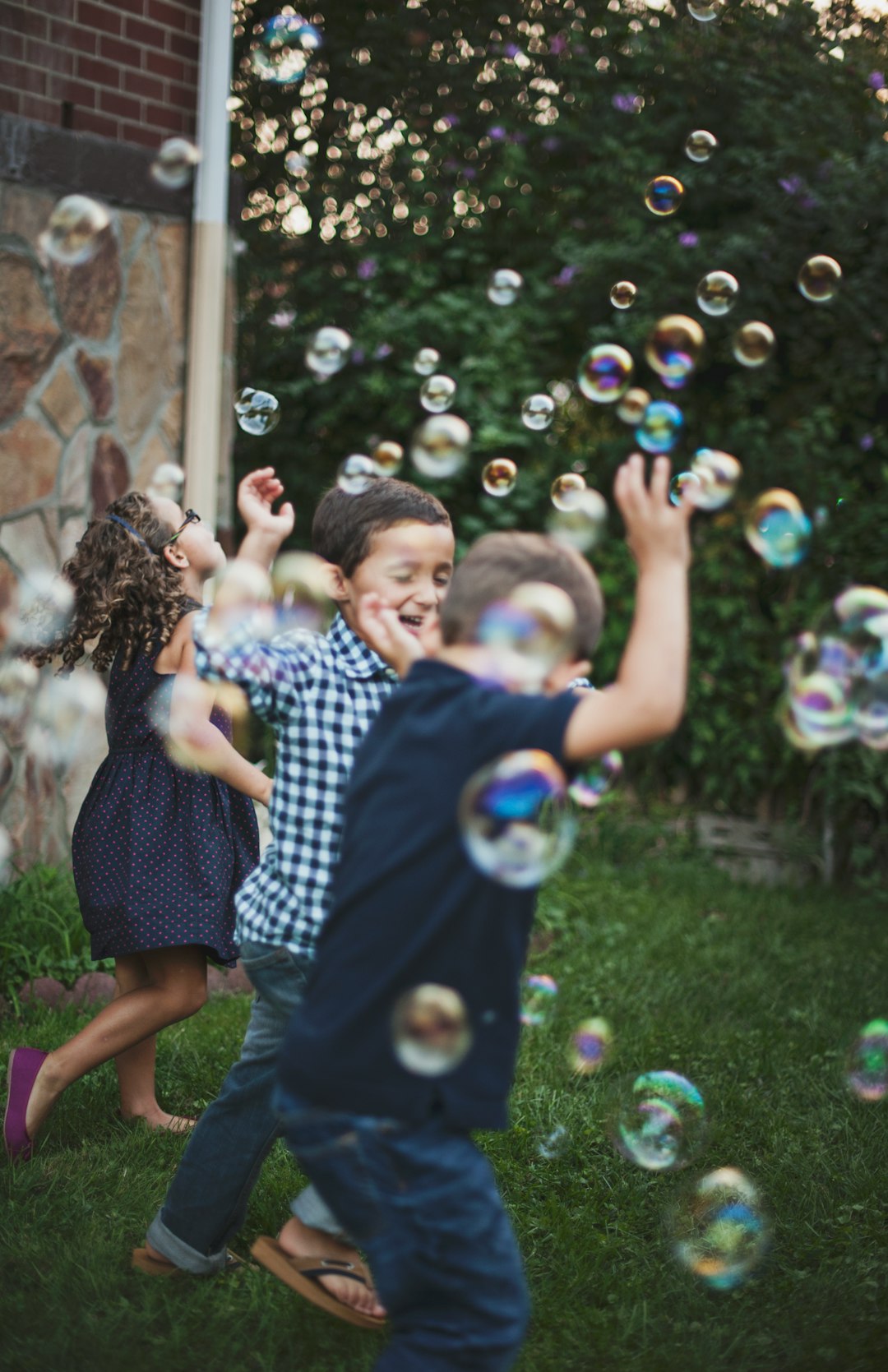 boy in blue and white polka dot shirt playing bubbles