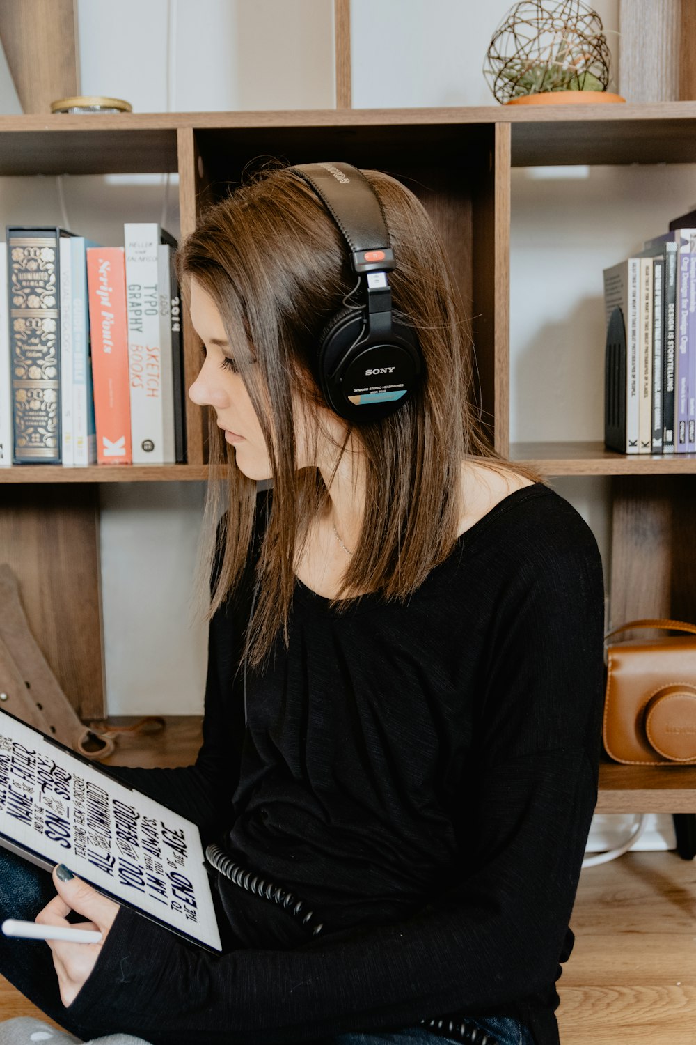 Mujer con camisa negra de manga larga con auriculares negros