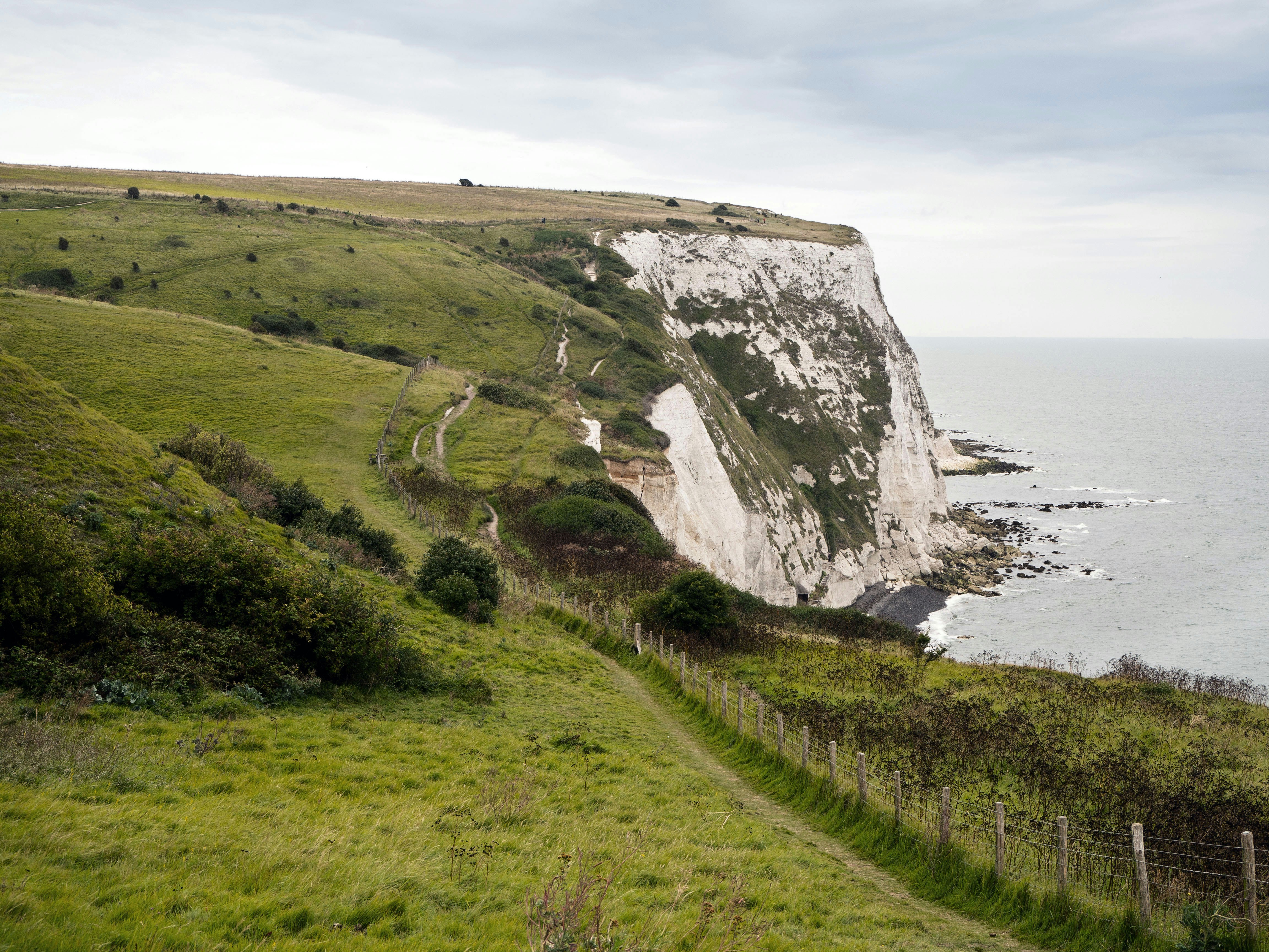green grass field near body of water during daytime, Hiking path along the White Cliffs of Dover