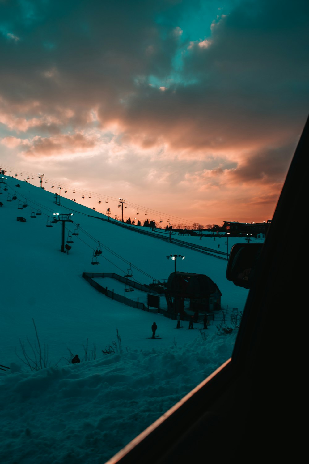 pessoas andando no chão coberto de neve durante o pôr do sol