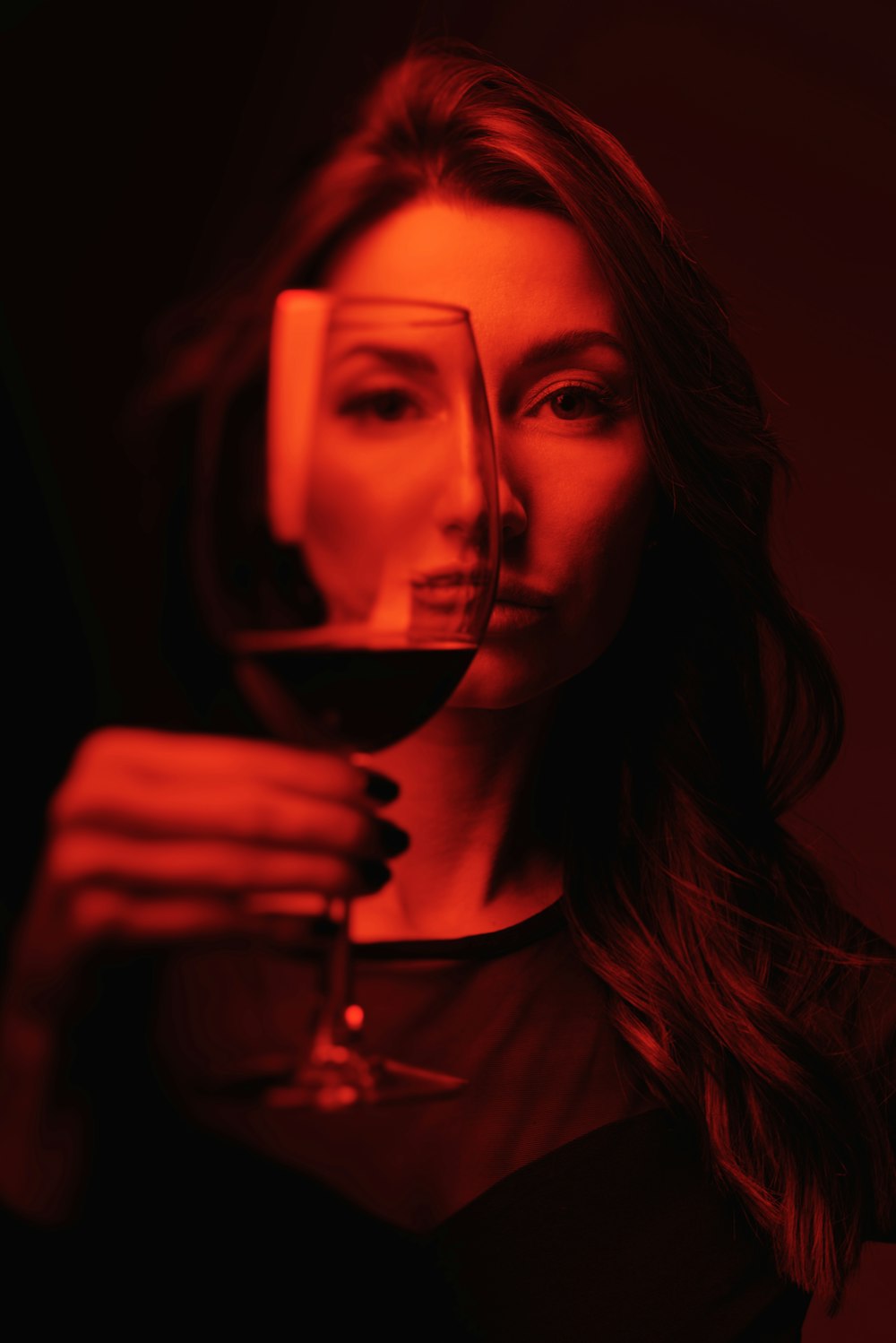 Frau in schwarzem Rundhalsshirt mit Weinglas