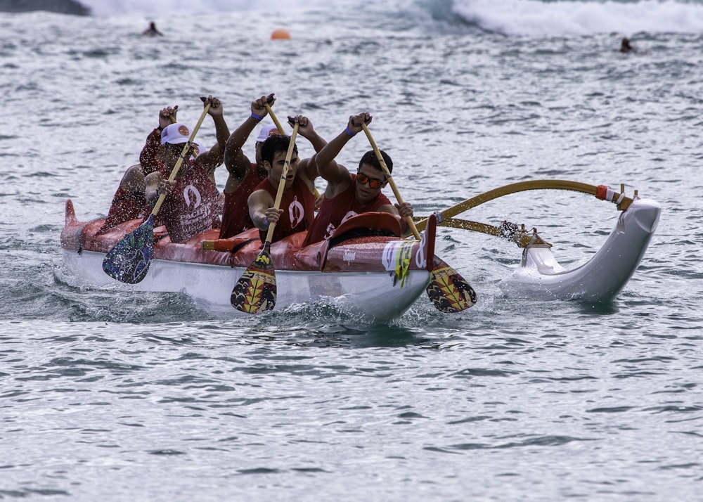 people riding on white and red boat on sea during daytime