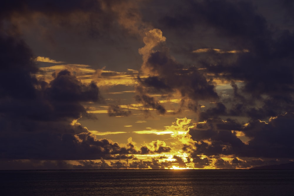 body of water under cloudy sky during sunset